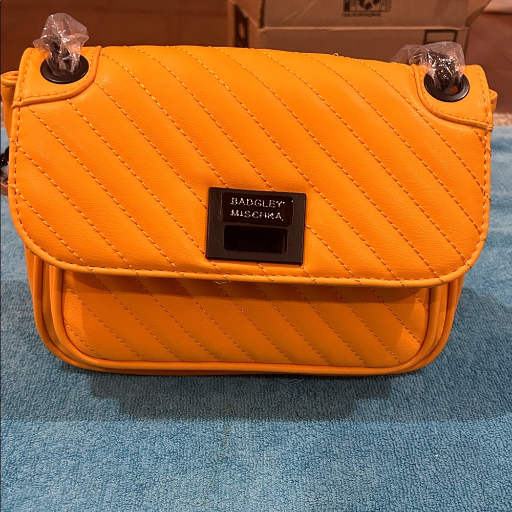 Badgley Mischka Bright Yellow /orange with two zippered pockets.